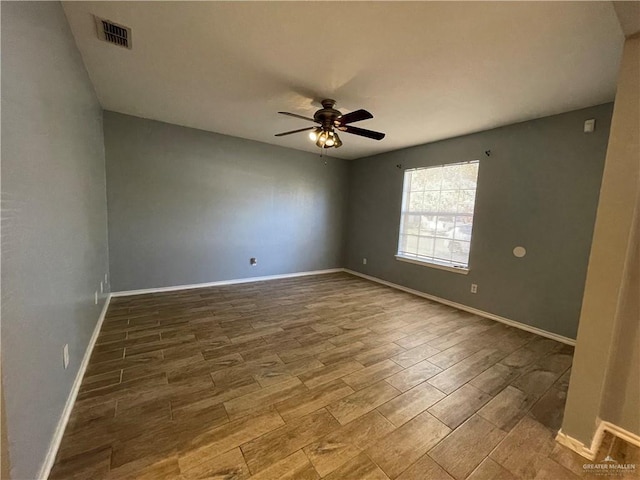 spare room with visible vents, baseboards, ceiling fan, and wood finished floors