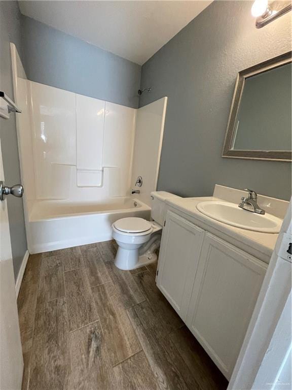 full bathroom featuring wood finish floors, shower / bathing tub combination, toilet, and vanity