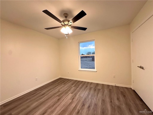 spare room with ceiling fan, baseboards, and dark wood-type flooring