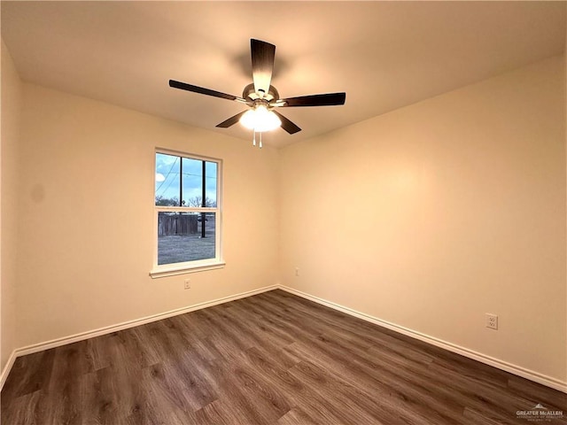 unfurnished room featuring ceiling fan, dark wood-type flooring, and baseboards