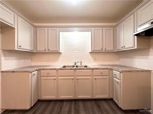 kitchen with dark wood-style floors, light countertops, a sink, and decorative backsplash