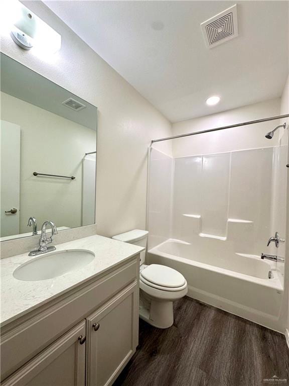 full bathroom with toilet, bathing tub / shower combination, wood finished floors, and visible vents