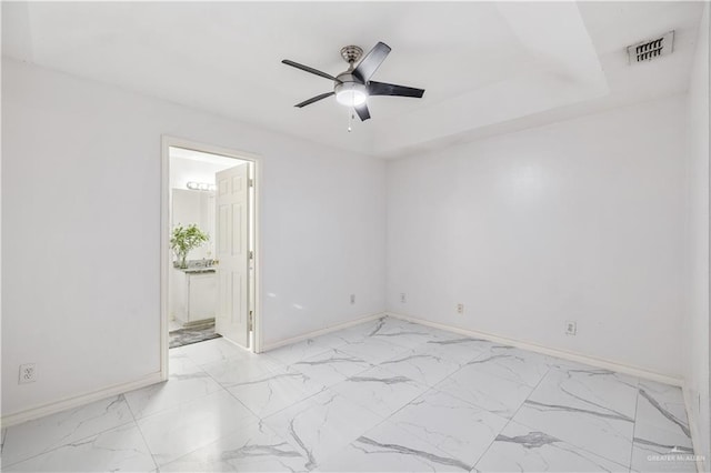 unfurnished room with a raised ceiling and ceiling fan