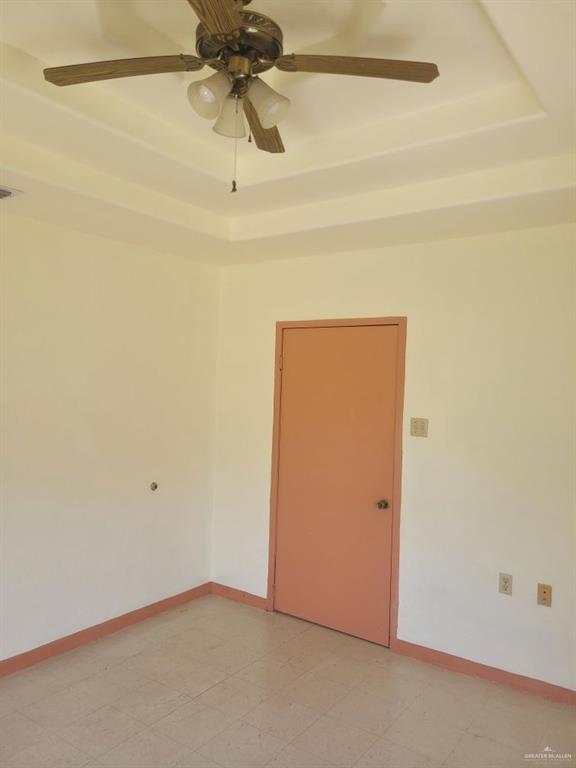 233 W 4th St, La Joya, TX 78560 - spare room featuring a tray ceiling, ceiling fan, and baseboards