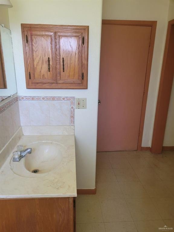 233 W 4th St, La Joya, TX 78560 - bathroom featuring vanity, tile patterned flooring, and baseboards