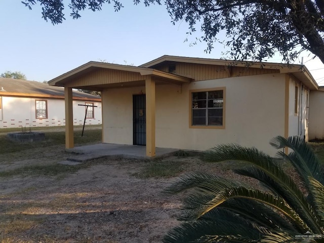 233 W 4th St, La Joya, TX 78560 - view of front of home featuring an attached carport and stucco siding