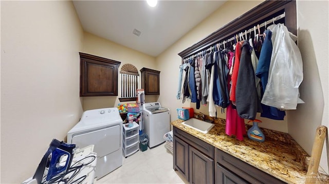 laundry area with washing machine and dryer, sink, and cabinets