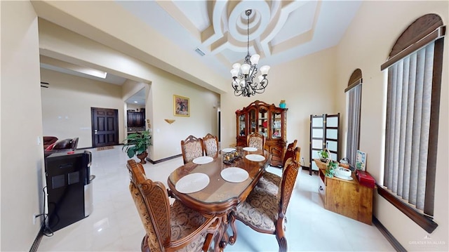 dining area featuring a raised ceiling, light tile patterned floors, and a chandelier