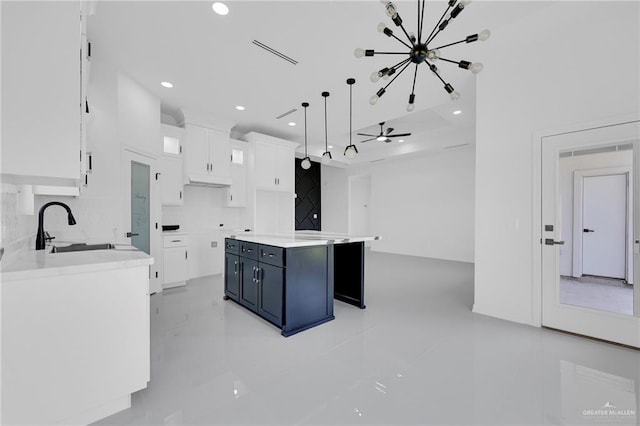 3433 E Kidd Ave, Edinburg, TX 78542 - kitchen featuring white cabinetry, a center island, a chandelier, backsplash, and a sink