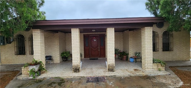 view of exterior entry featuring brick siding