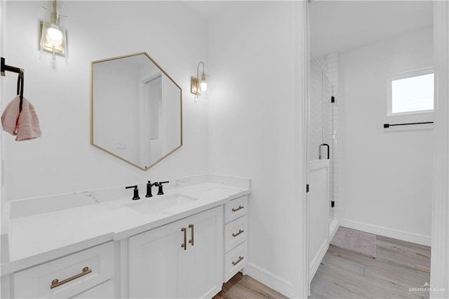 bathroom featuring hardwood / wood-style flooring, vanity, and a shower with shower door