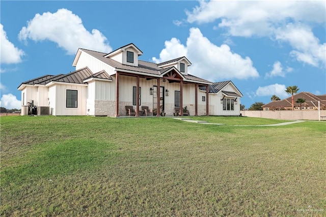 view of front of home with central AC and a front yard