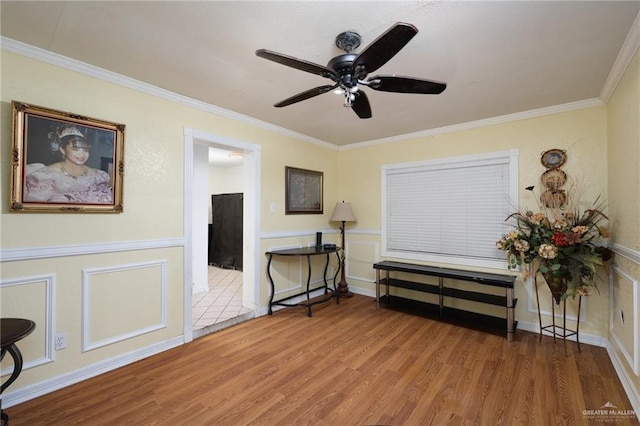 interior space featuring wood-type flooring, ornamental molding, and ceiling fan