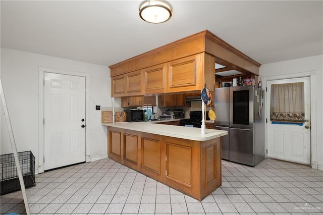 kitchen with stainless steel refrigerator, kitchen peninsula, and stove