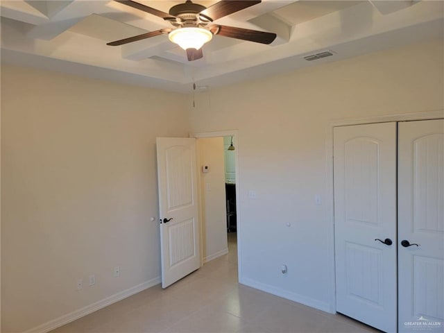 unfurnished bedroom featuring a raised ceiling, a closet, and ceiling fan