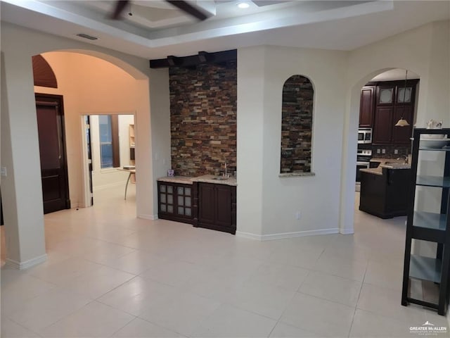 hall with a raised ceiling and light tile patterned flooring