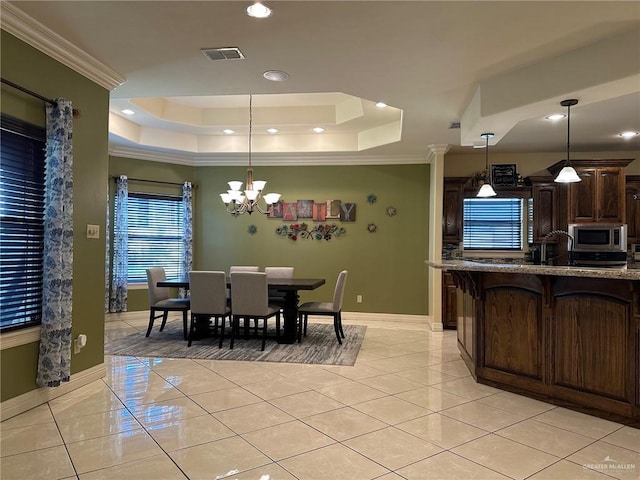 5845 Acacia St, Harlingen, TX 78552 - dining room with a tray ceiling, crown molding, baseboards, light tile patterned floors, and a chandelier