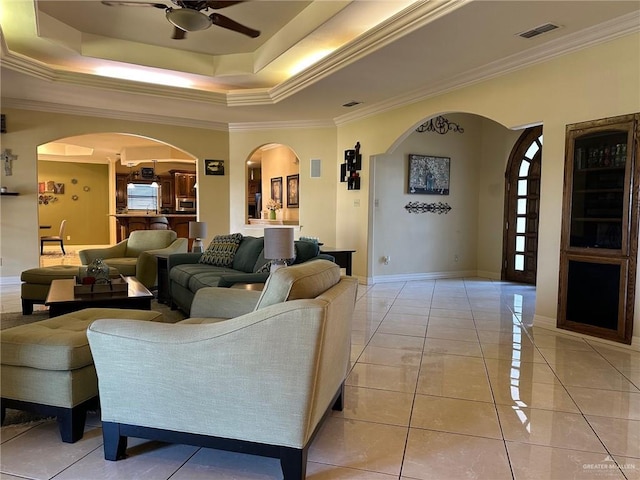 5845 Acacia St, Harlingen, TX 78552 - living room featuring arched walkways, a ceiling fan, crown molding, baseboards, and a raised ceiling