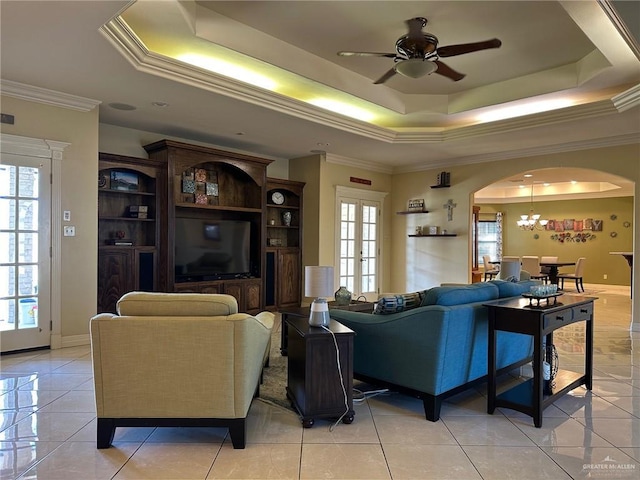 5845 Acacia St, Harlingen, TX 78552 - living room featuring a tray ceiling, a ceiling fan, crown molding, a chandelier, and arched walkways