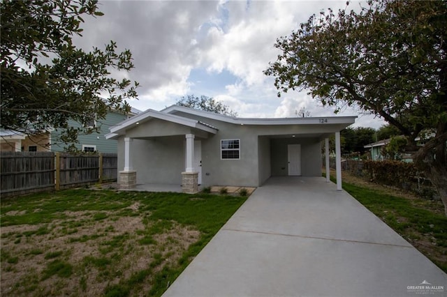 rear view of property with a carport and a lawn