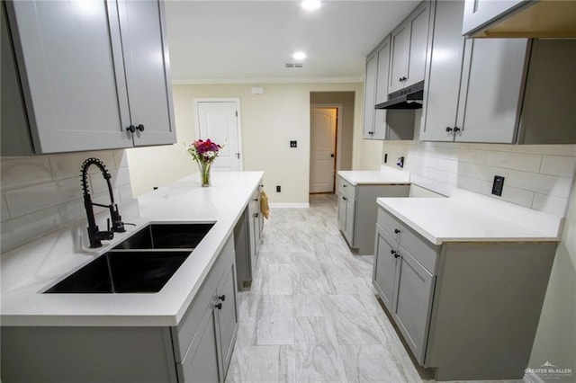 kitchen featuring tasteful backsplash, sink, crown molding, and gray cabinets