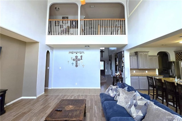 living room featuring a high ceiling and dark hardwood / wood-style flooring