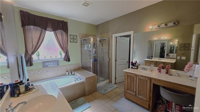 bathroom featuring tile patterned floors, vanity, and shower with separate bathtub