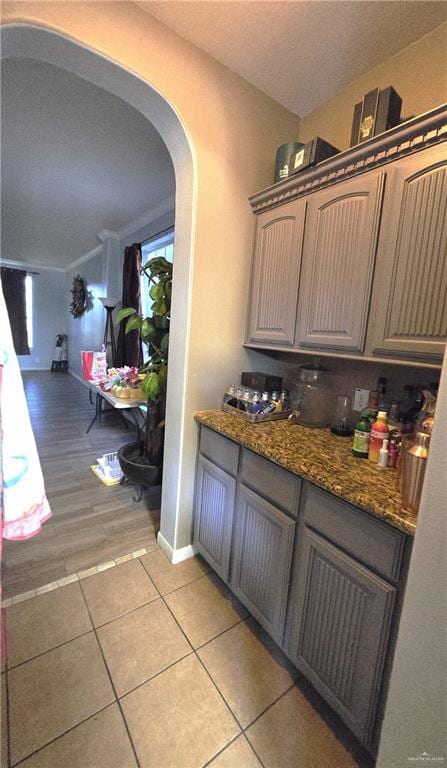 interior space featuring ornamental molding, dark stone counters, and light hardwood / wood-style flooring