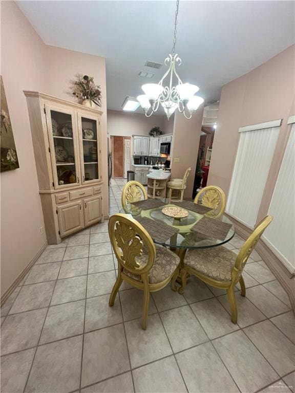 dining space featuring light tile patterned floors and a notable chandelier