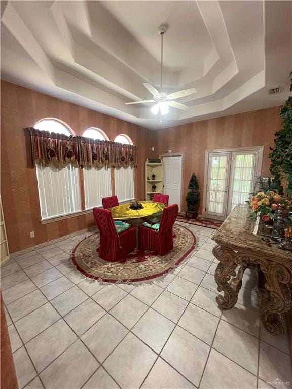 dining room with ceiling fan, light tile patterned floors, a tray ceiling, and french doors