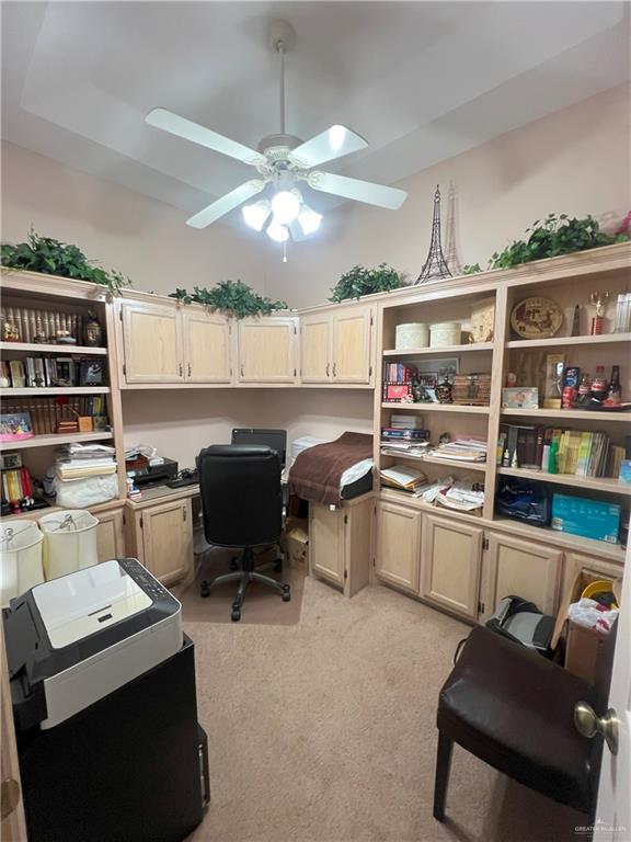 carpeted home office featuring ceiling fan