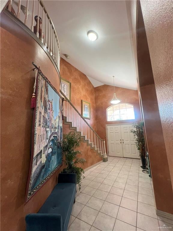 entrance foyer featuring light tile patterned floors and high vaulted ceiling