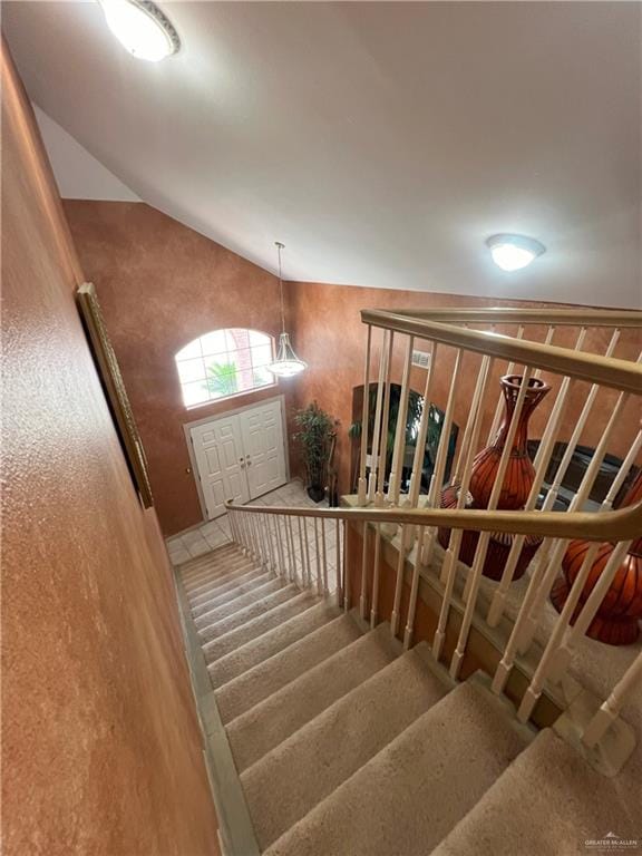 stairway featuring vaulted ceiling