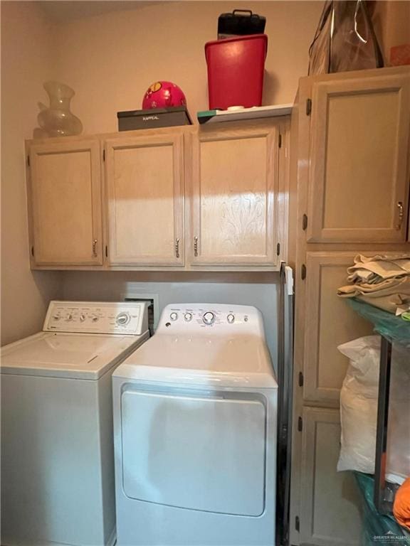 clothes washing area with cabinets and independent washer and dryer