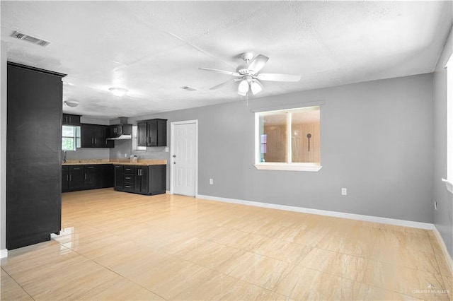 3109 Raul Gonzalez Dr, Mercedes, TX 78570 - unfurnished living room with a ceiling fan and a textured ceiling