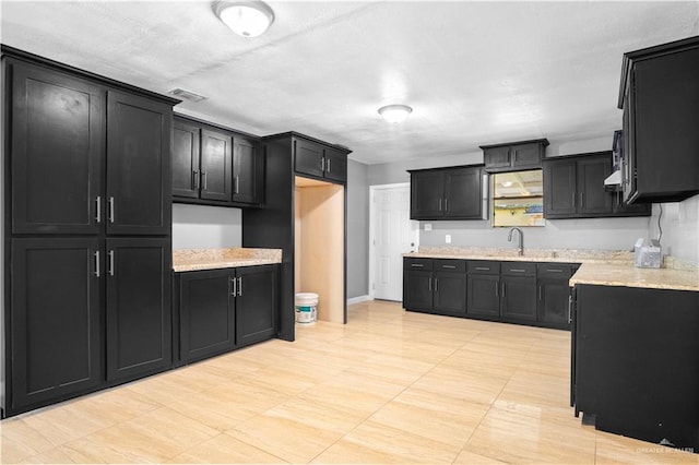 3109 Raul Gonzalez Dr, Mercedes, TX 78570 - kitchen with dark cabinets and light stone countertops