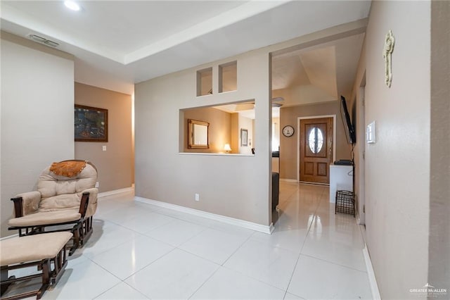hall featuring light tile patterned flooring, visible vents, and baseboards
