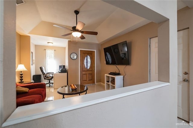 living room with ceiling fan and a tray ceiling