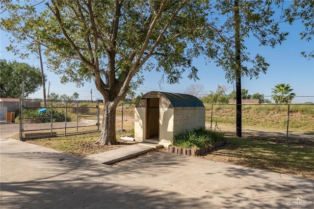 exterior space with fence, a gate, a shed, and an outbuilding