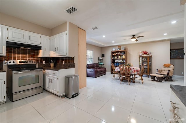 kitchen featuring visible vents, dark countertops, under cabinet range hood, open floor plan, and stainless steel electric range