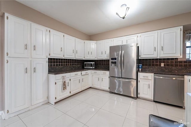 kitchen featuring appliances with stainless steel finishes, light tile patterned floors, decorative backsplash, and white cabinets