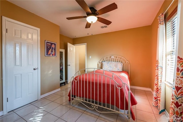 bedroom featuring tile patterned flooring, visible vents, a ceiling fan, and baseboards
