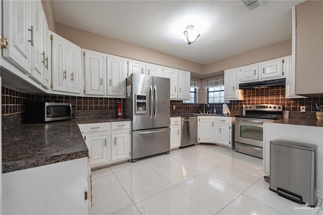 kitchen with dark countertops, visible vents, stainless steel appliances, and under cabinet range hood