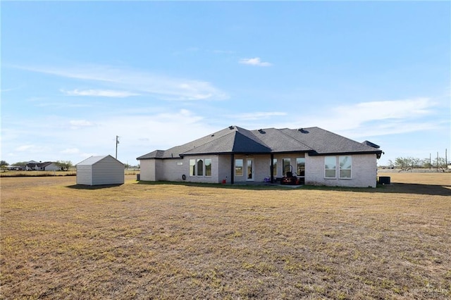 rear view of property with a yard and a shed