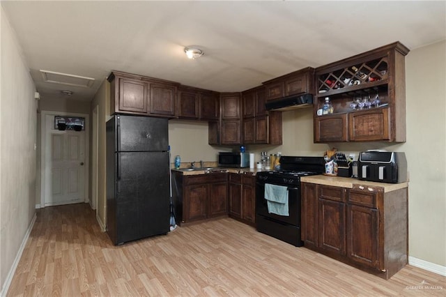 kitchen with dark brown cabinetry, sink, black appliances, and light wood-type flooring