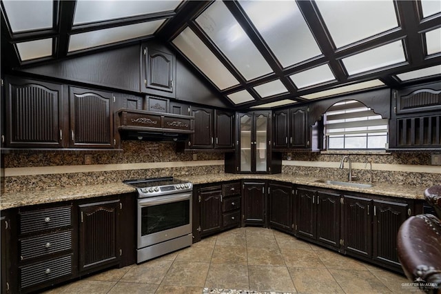 kitchen featuring light stone countertops, stainless steel range, sink, backsplash, and vaulted ceiling