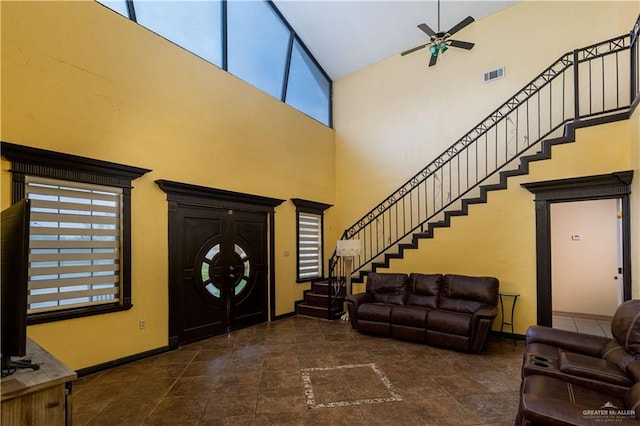 foyer with ceiling fan and high vaulted ceiling