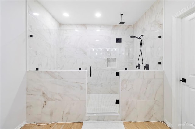 bathroom featuring hardwood / wood-style flooring and a shower with shower door