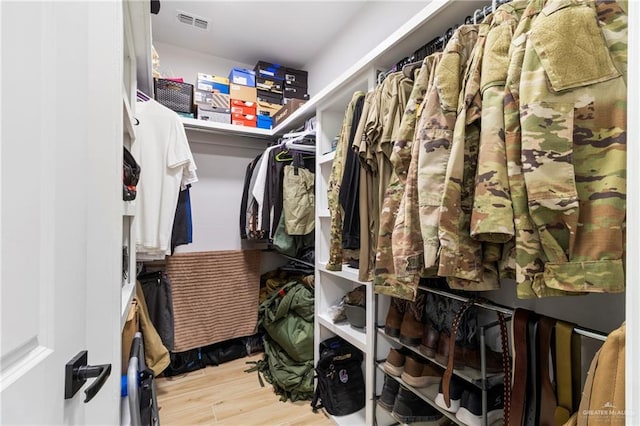 walk in closet with light hardwood / wood-style floors