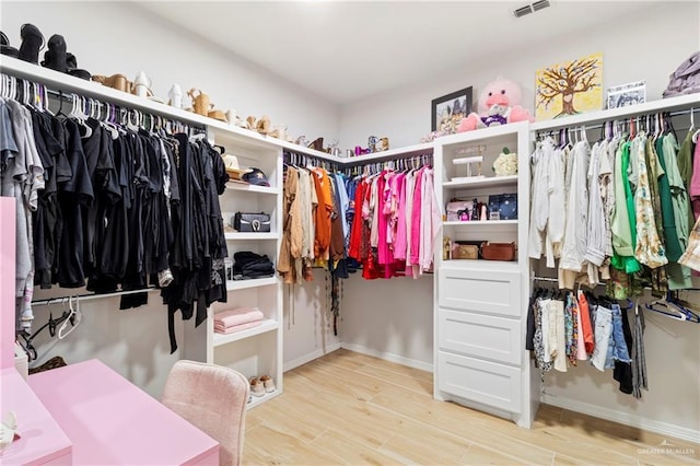 walk in closet with light wood-type flooring